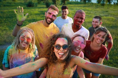 Happy friends covered with colorful powder dyes outdoors. Holi festival celebration