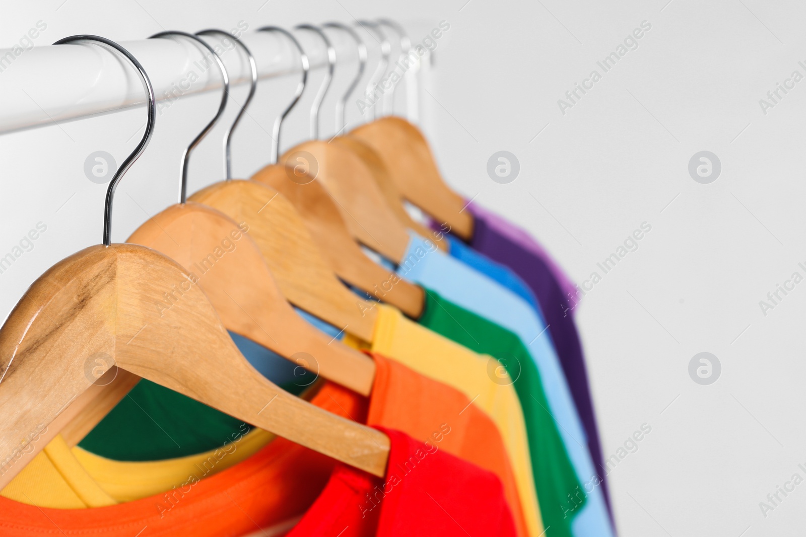 Photo of Colorful clothes on hangers against white background