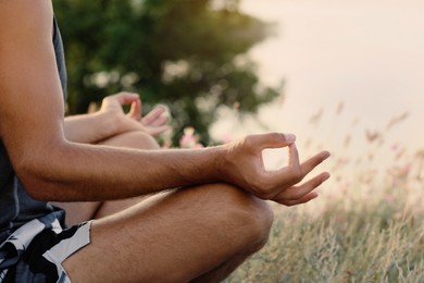 Photo of Man meditating outdoors on summer day, closeup