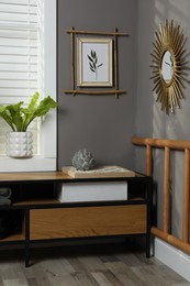 Photo of Stylish room interior with bamboo frame on grey wall