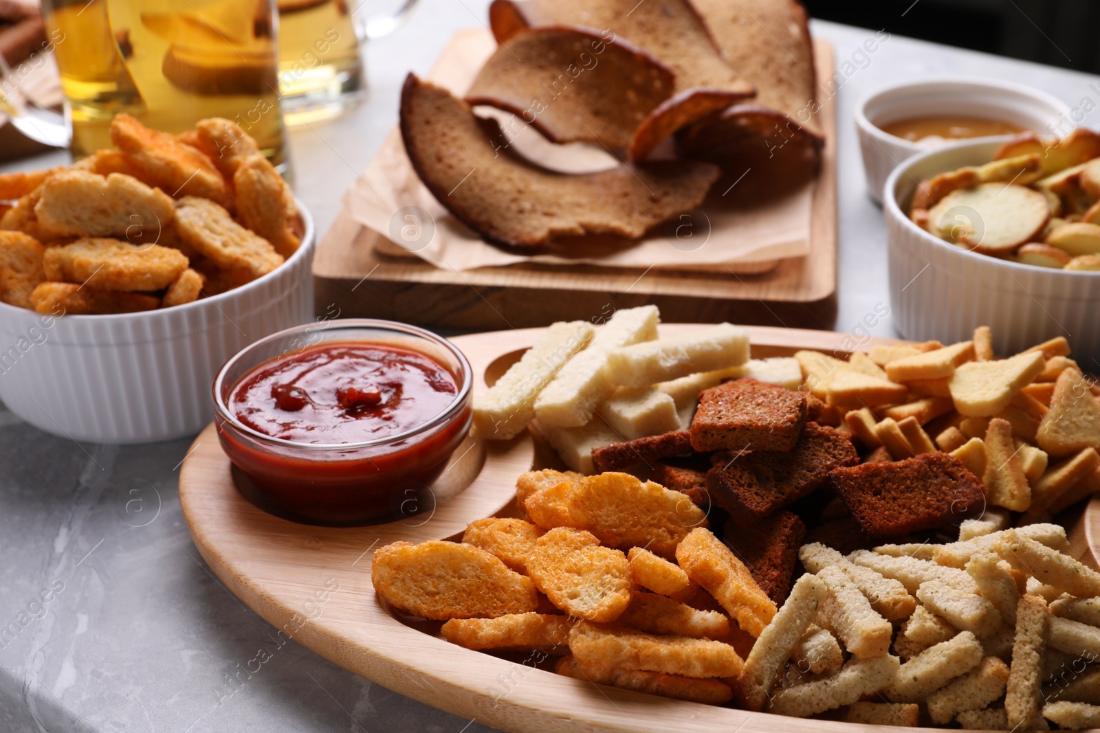 Photo of Different crispy rusks with dip sauce on light table