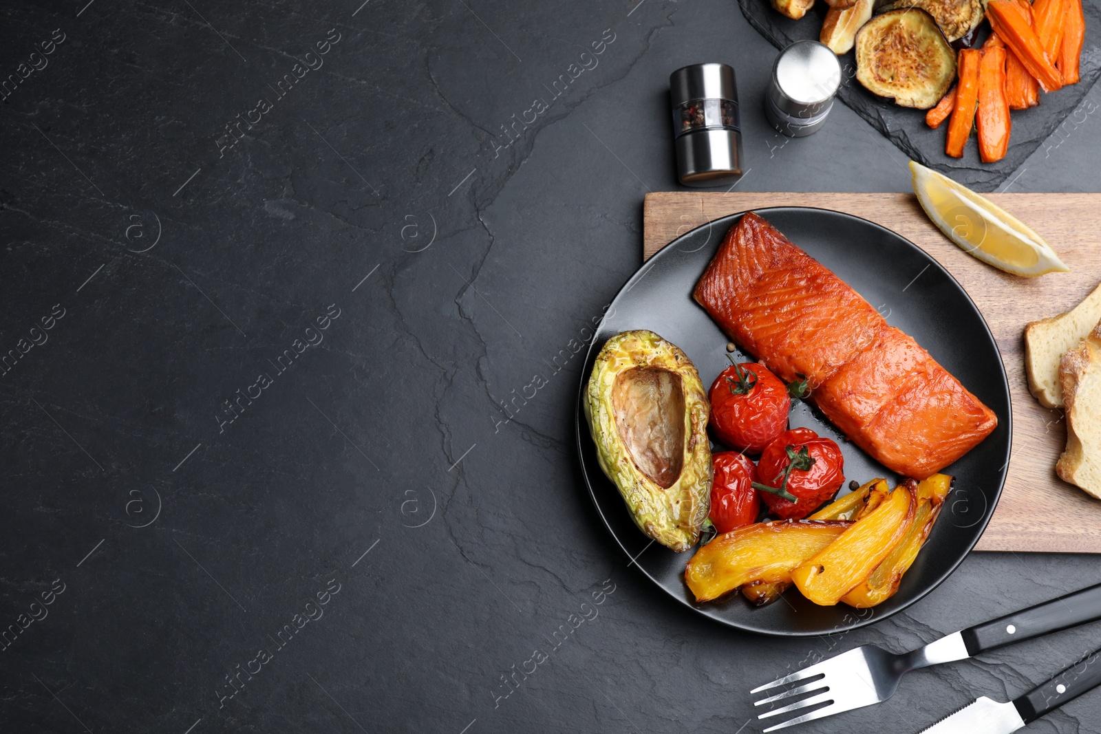 Photo of Delicious cooked salmon and vegetables served on black table, flat lay. with space for text. Healthy meals from air fryer