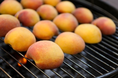 Photo of Modern grill with tasty juicy peaches, closeup