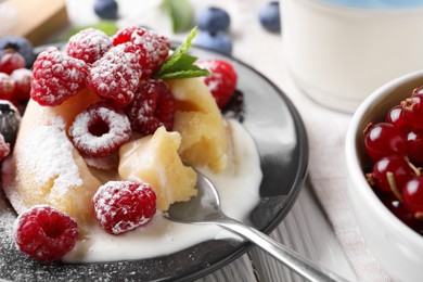 Delicious vanilla fondant served with fresh berries on white wooden table, closeup