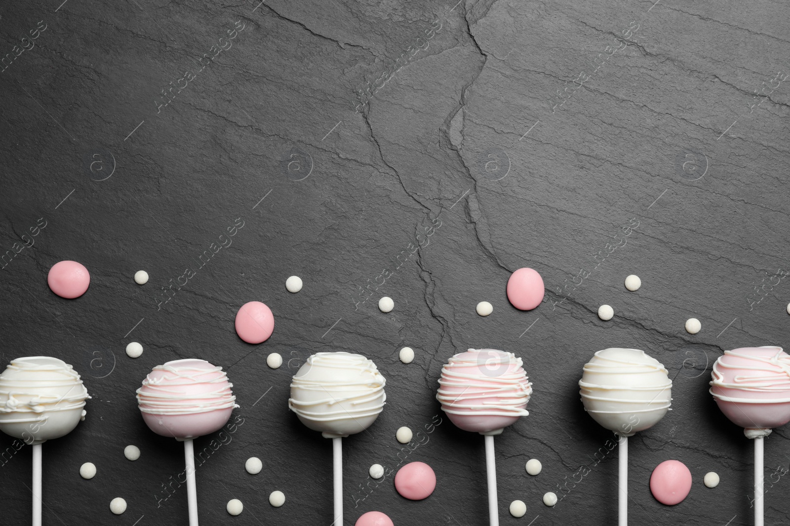 Photo of Flat lay composition with sweet cake pops on black background. Space for text