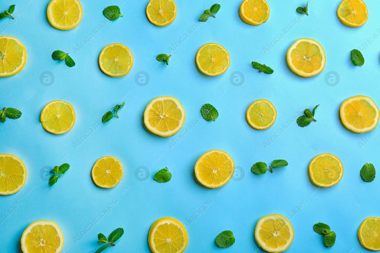 Photo of Lemonade layout with juicy lemon slices and mint on light blue background, top view