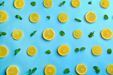 Lemonade layout with juicy lemon slices and mint on light blue background, top view