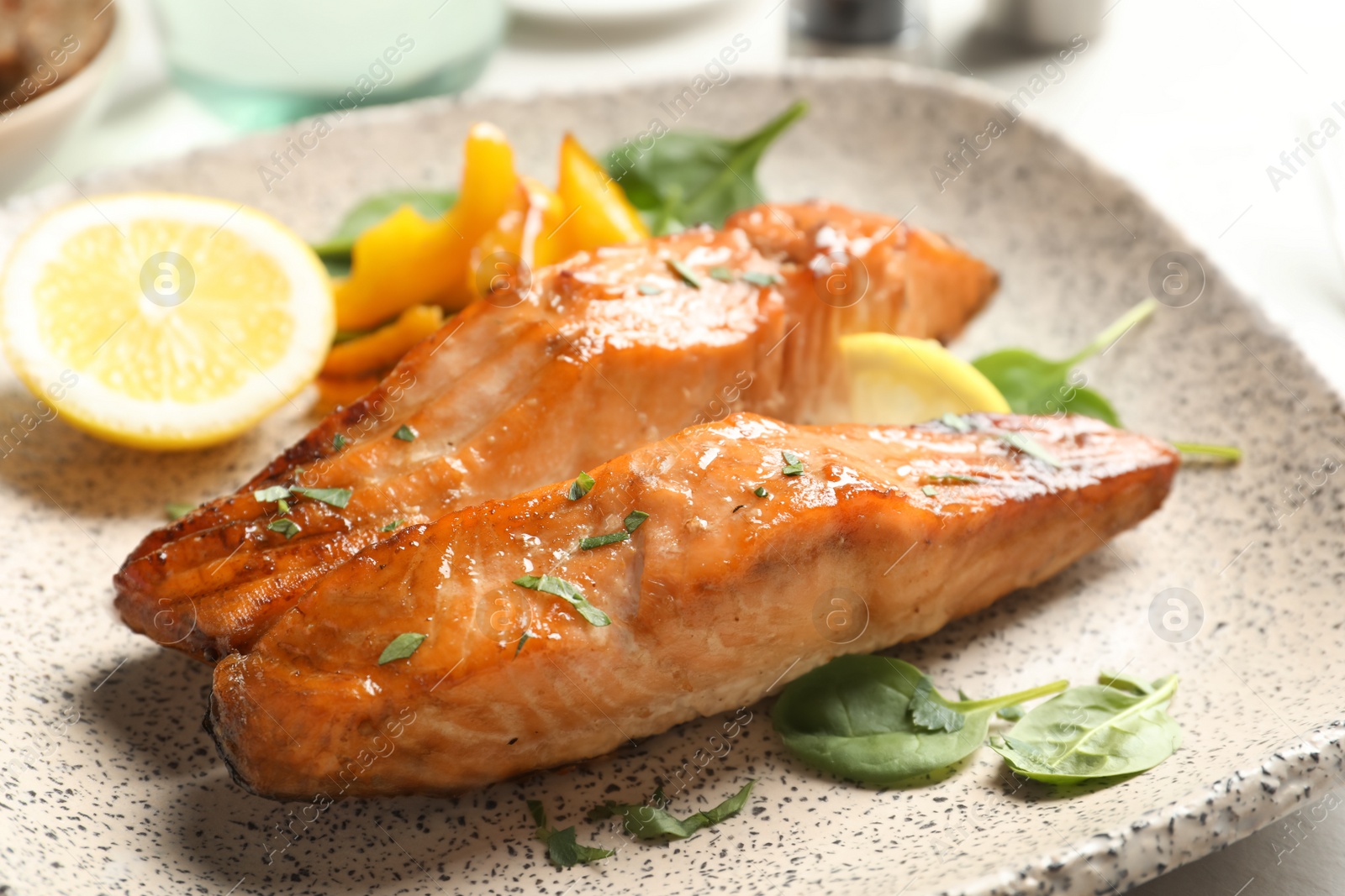 Photo of Tasty cooked salmon with lemon on plate, closeup