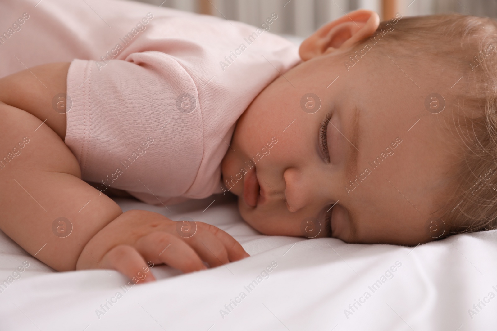 Photo of Adorable little baby sleeping on bed, closeup