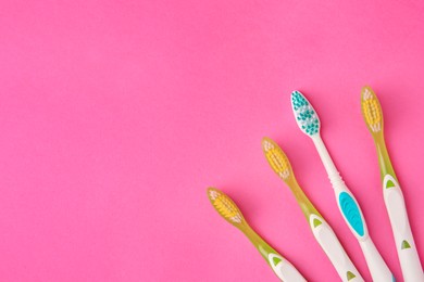 Photo of Toothbrushes on pink background, flat lay. Space for text