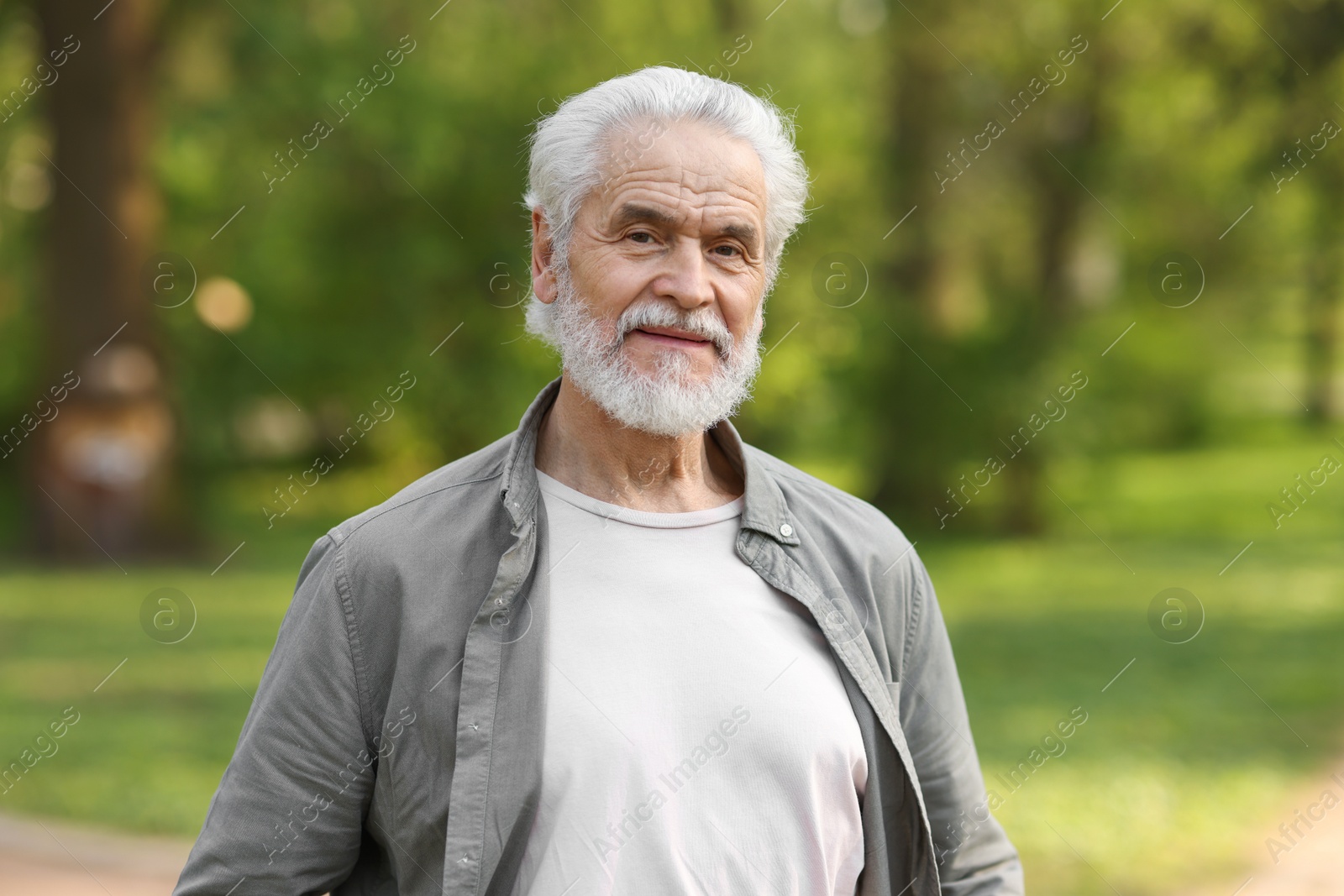 Photo of Portrait of happy grandpa in spring park