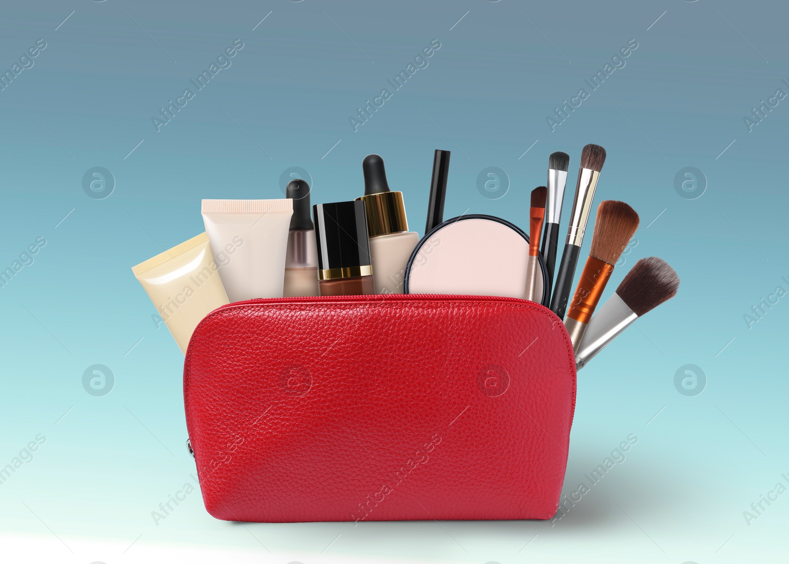 Image of Cosmetic bag filled with makeup products on color gradient background