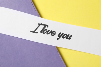 Card with text I Love You on color background, top view