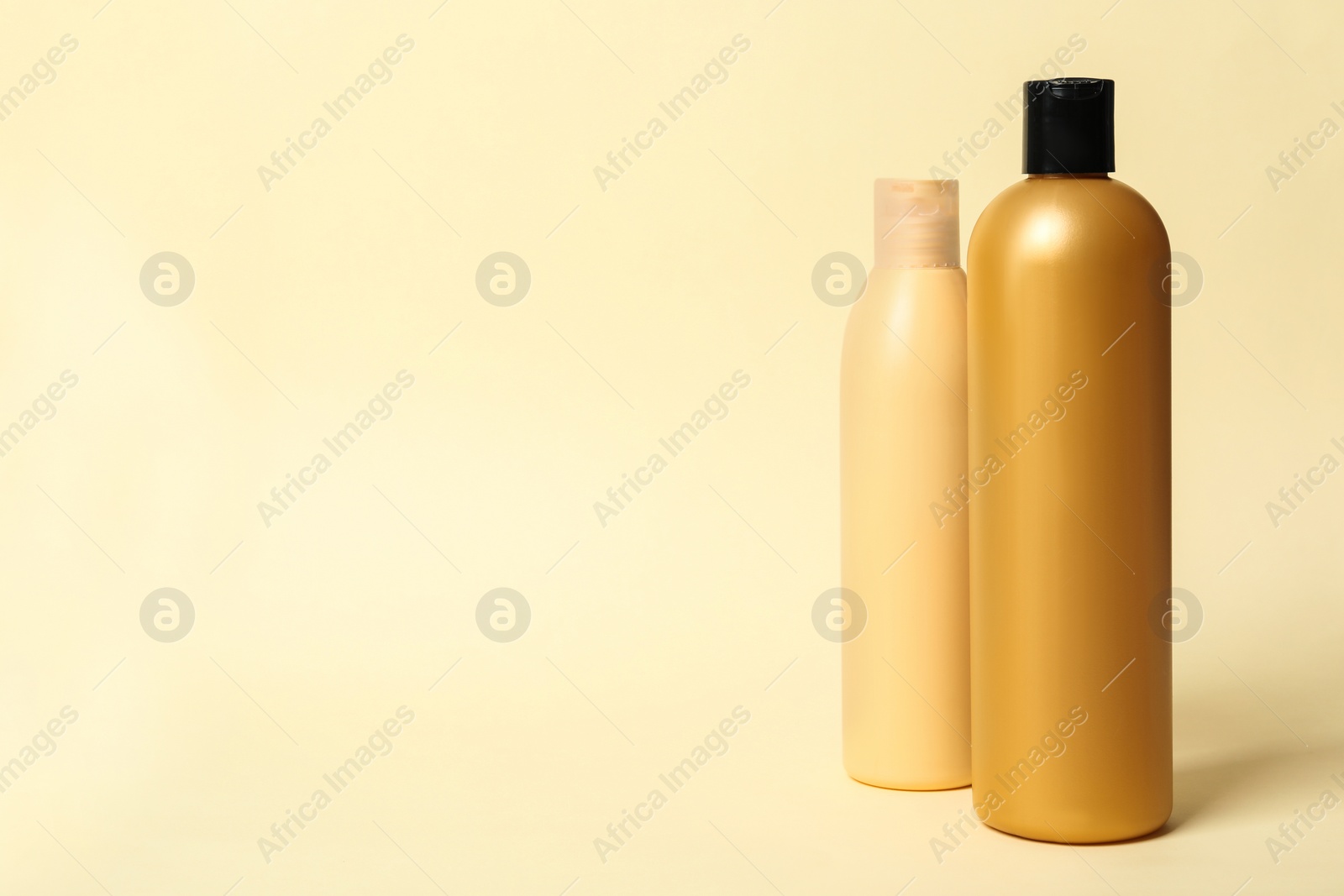 Photo of Bottles with cosmetic products on yellow background. Mockup for design