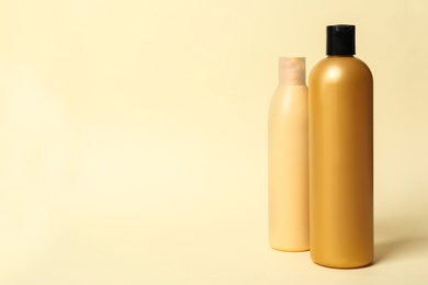 Photo of Bottles with cosmetic products on yellow background. Mockup for design