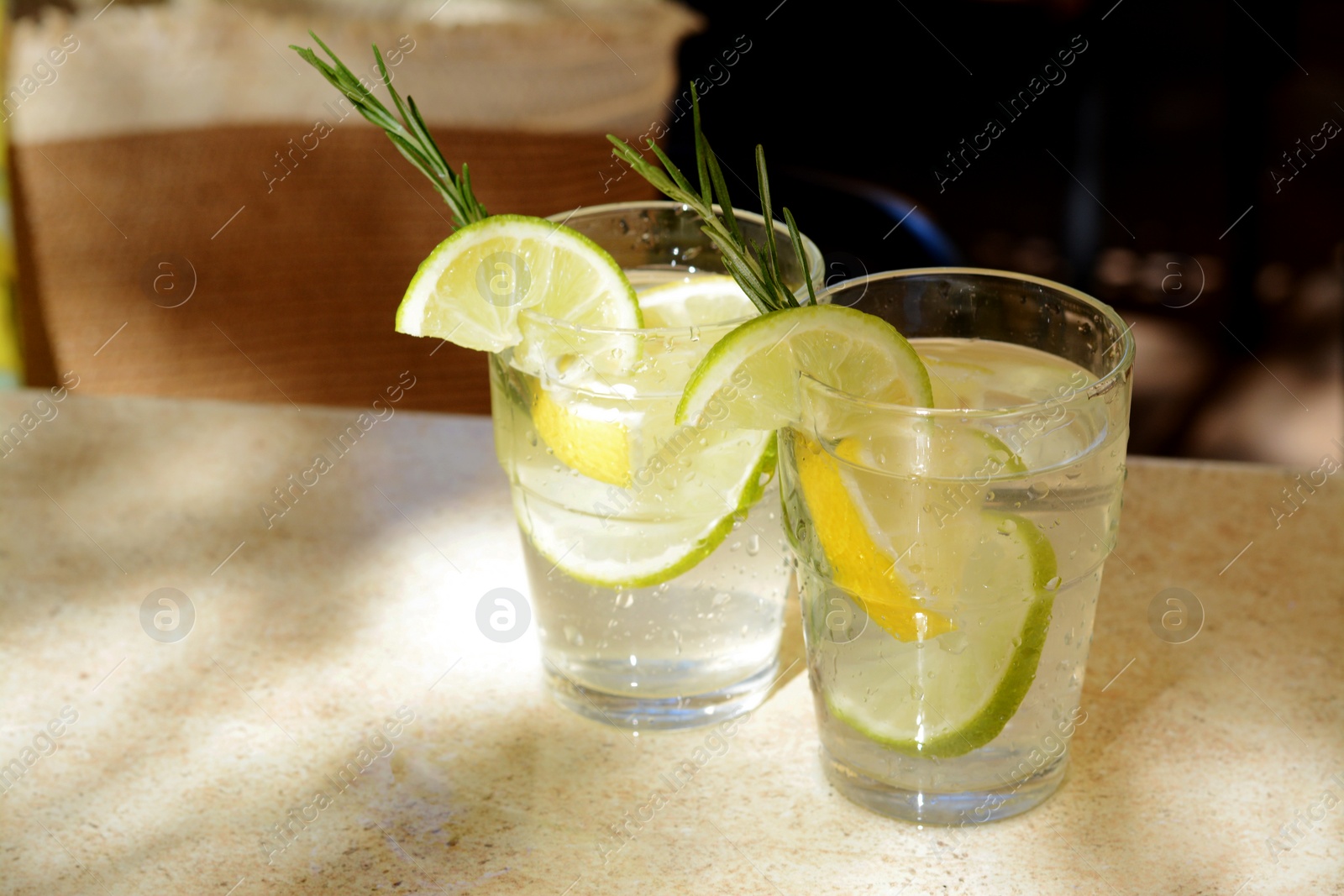 Photo of Glasses of tasty refreshing lemonade on light table, space for text. Summer drink