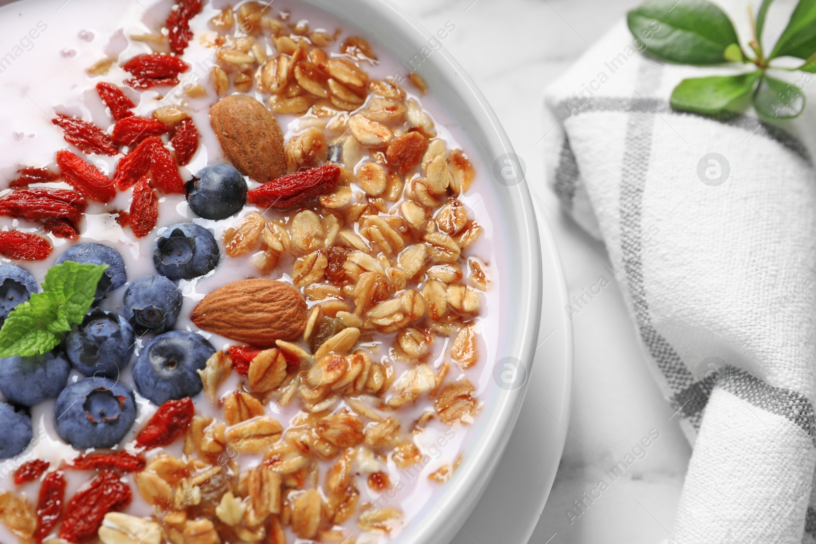 Photo of Smoothie bowl with goji berries on marble table, closeup