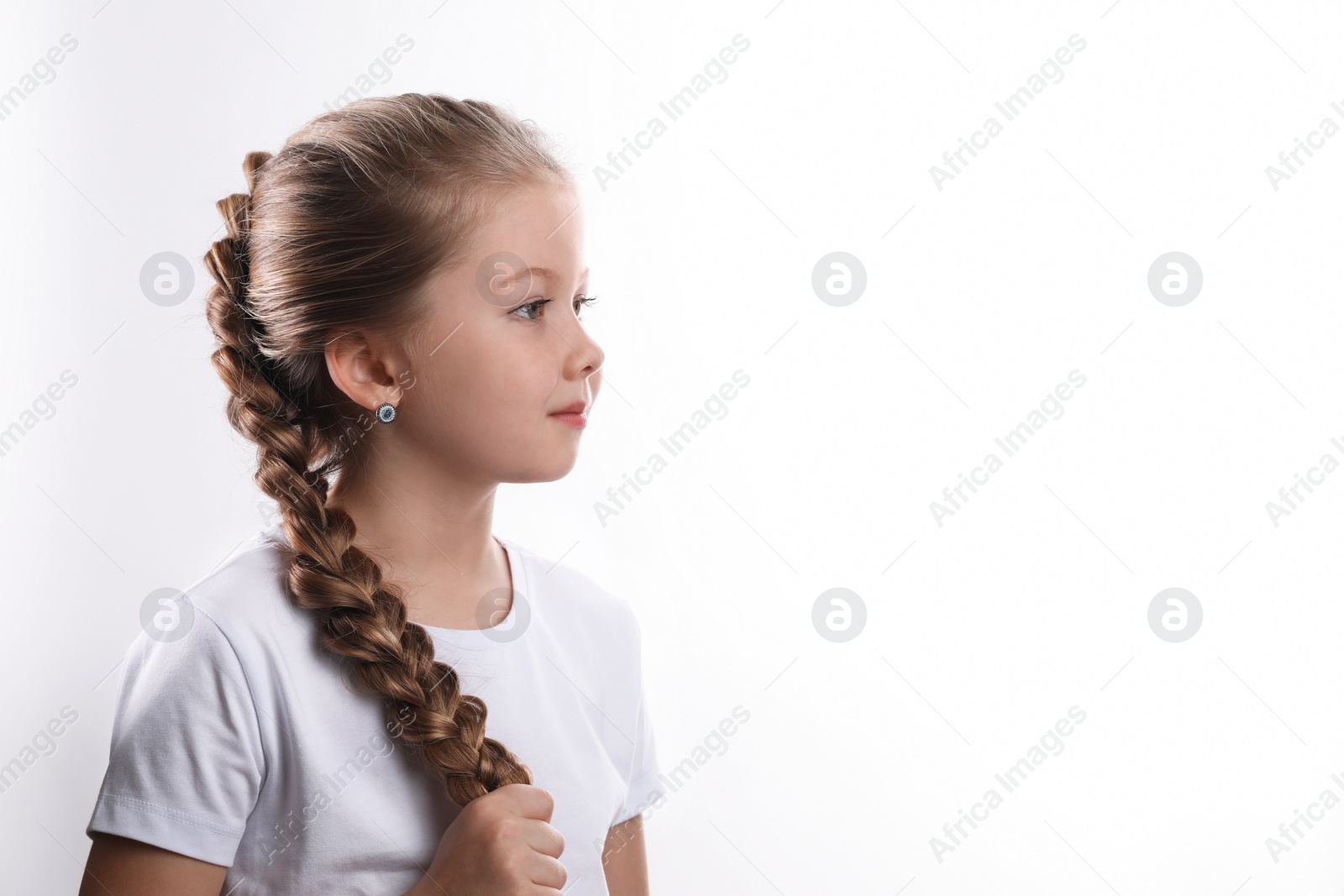 Photo of Little girl with braided hair on white background. Space for text