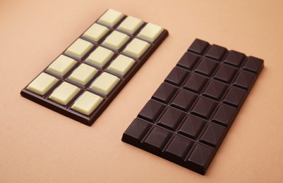 Two tasty chocolate bars on brown background