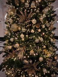 Photo of Beautiful Christmas tree decorated with baubles and festive lights indoors