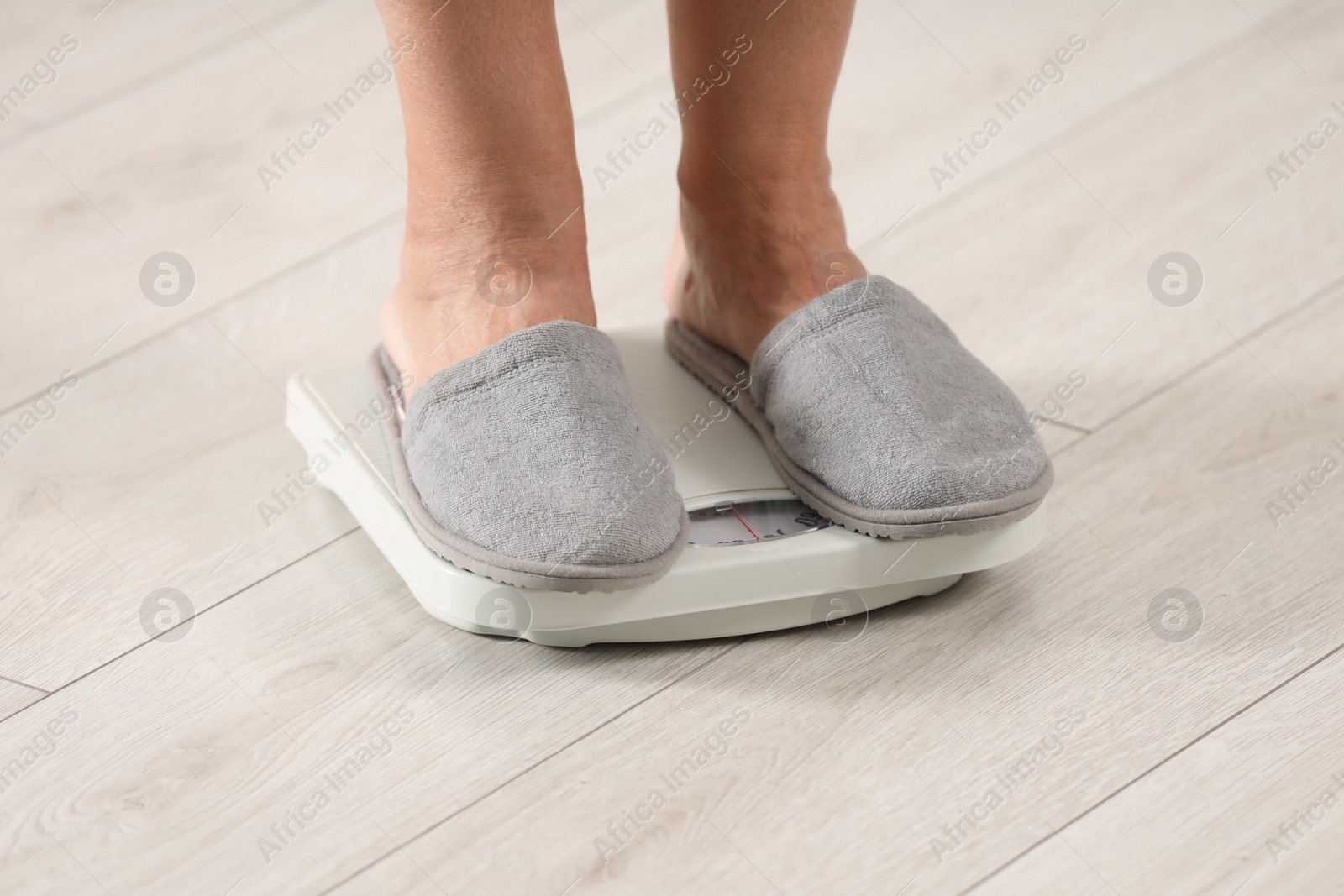 Photo of Menopause, weight gain. Woman standing on floor scales indoors, closeup