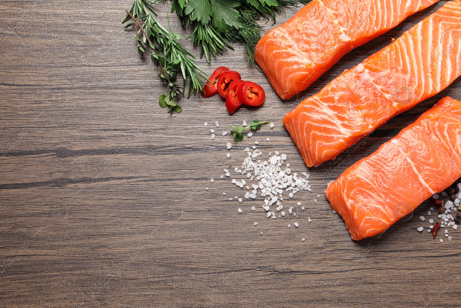 Photo of Fresh salmon and ingredients for marinade on wooden table, flat lay. Space for text