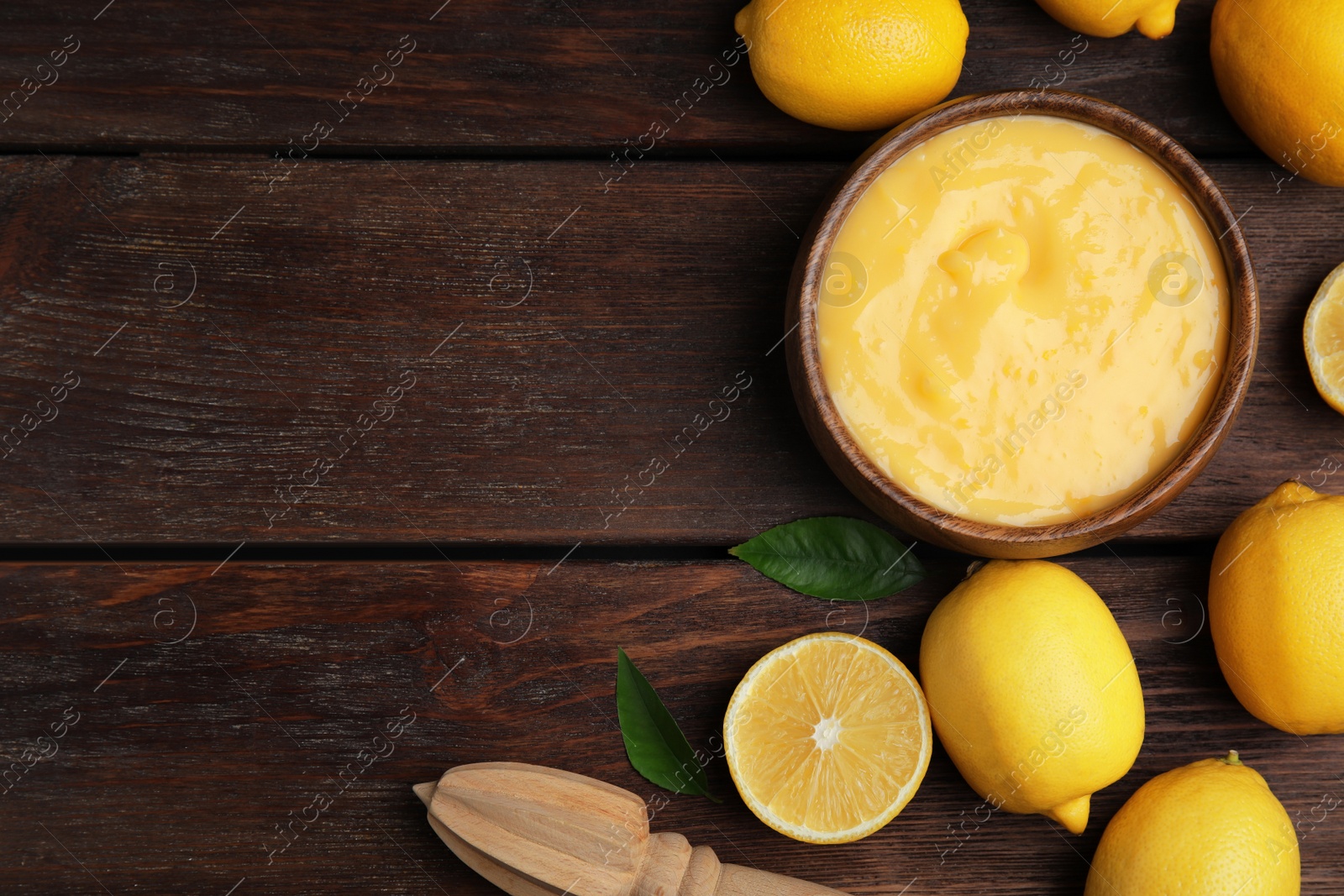 Photo of Delicious lemon curd and fresh fruits on wooden table, flat lay. Space for text