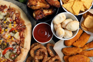 Pizza, onion rings and other fast food as background, top view