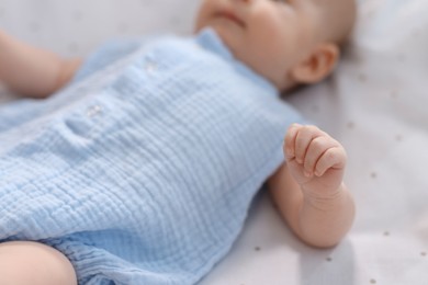 Photo of Cute little baby lying in crib at home, closeup