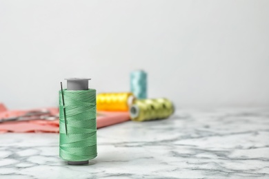 Photo of Color sewing thread with needle on table