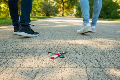 Photo of Men walking outside, focus on lost keys