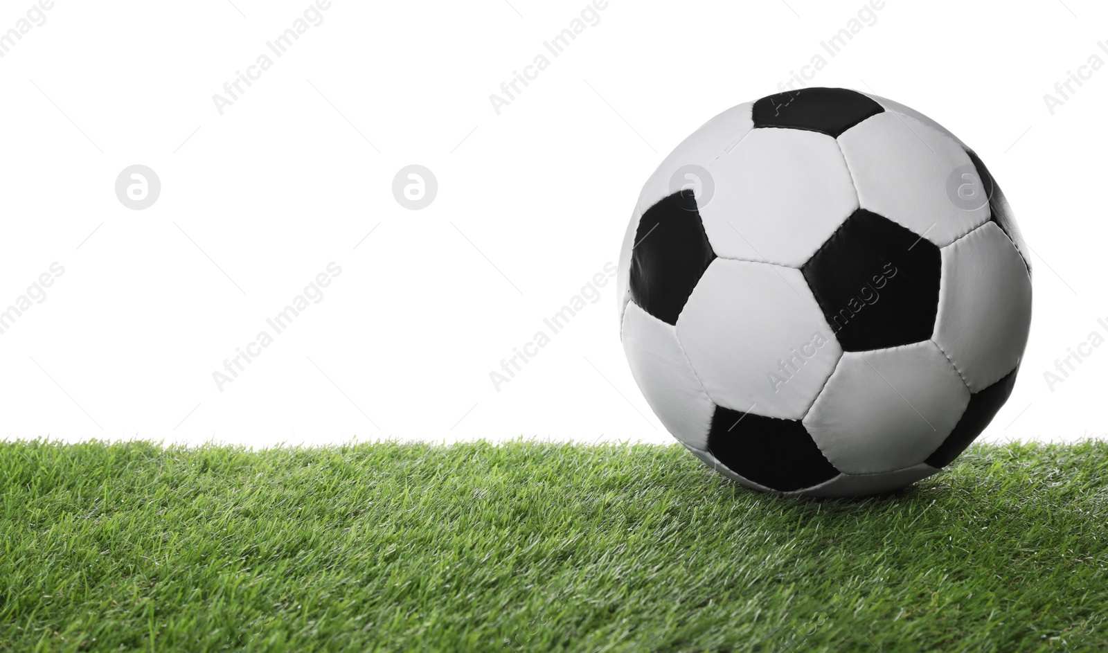 Photo of Football ball on green grass against white background. Space for text