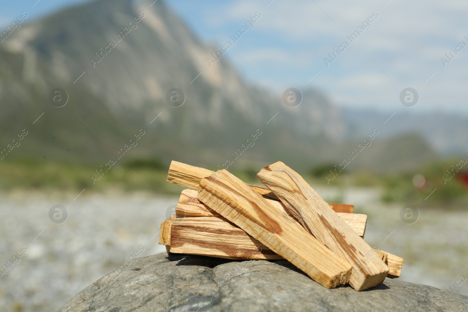 Photo of Many palo santo sticks on stone surface in high mountains, closeup