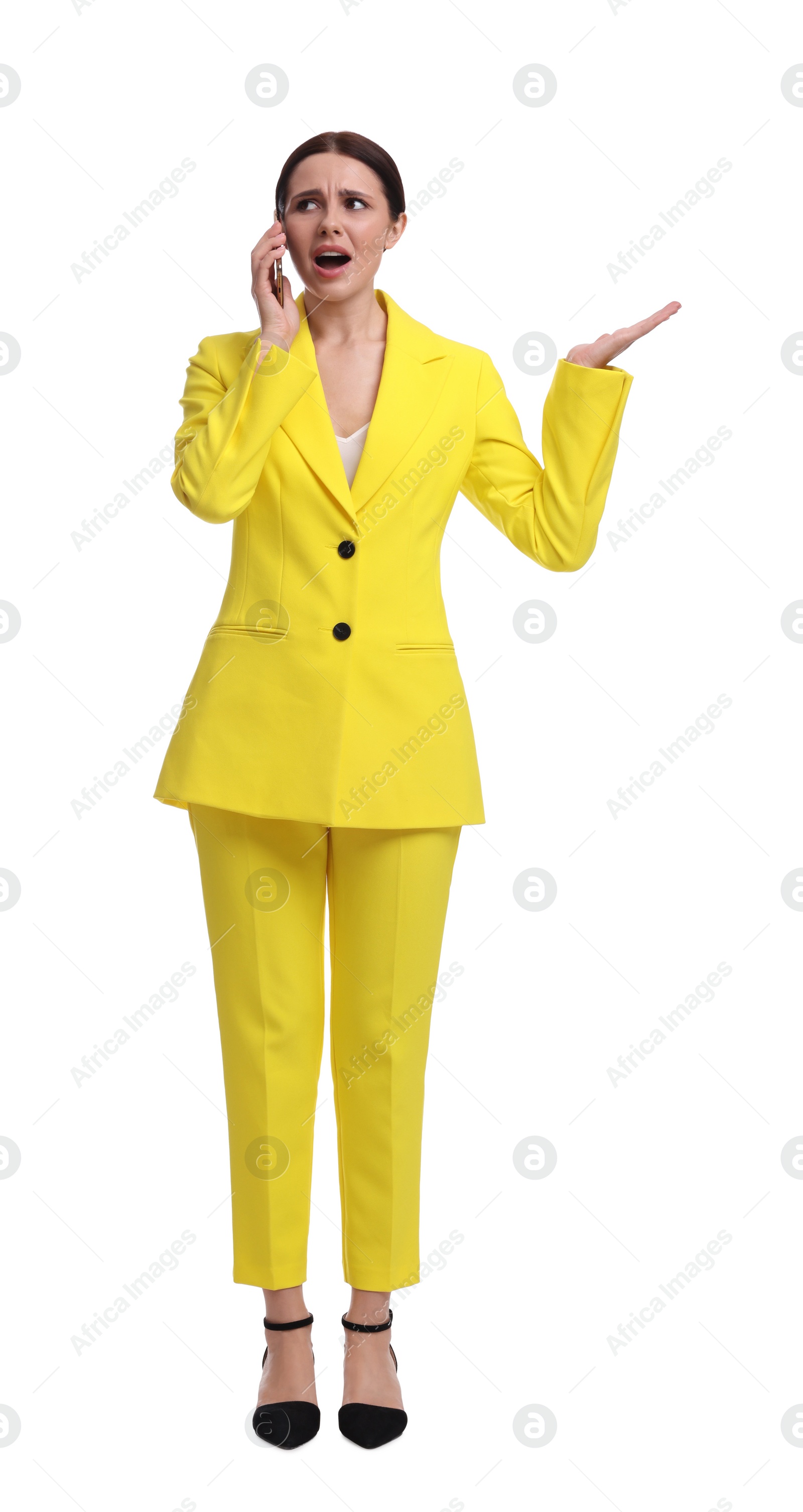 Photo of Beautiful businesswoman in yellow suit talking on smartphone against white background