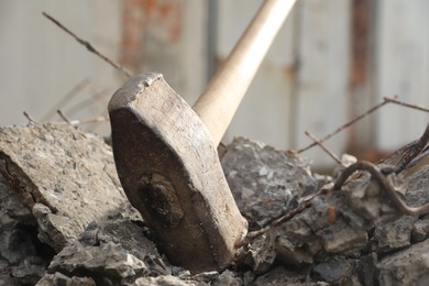 Sledgehammer on pile of broken stones outdoors, closeup