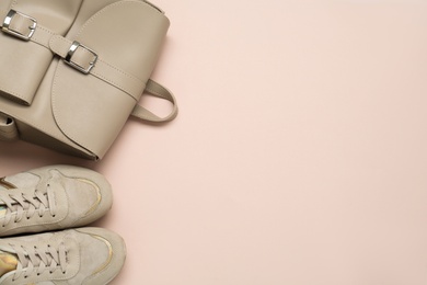 Backpack and sneakers on pink background, flat lay. Space for text