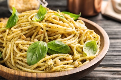 Photo of Plate of delicious basil pesto pasta on table, closeup
