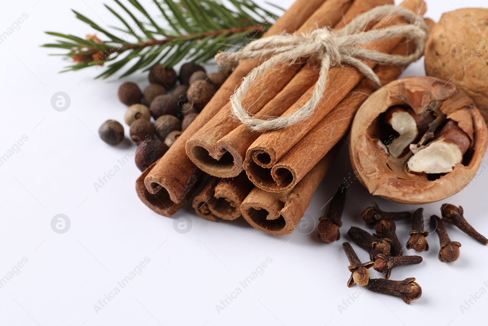 Photo of Different spices, nuts and fir branch on white table, closeup. Space for text