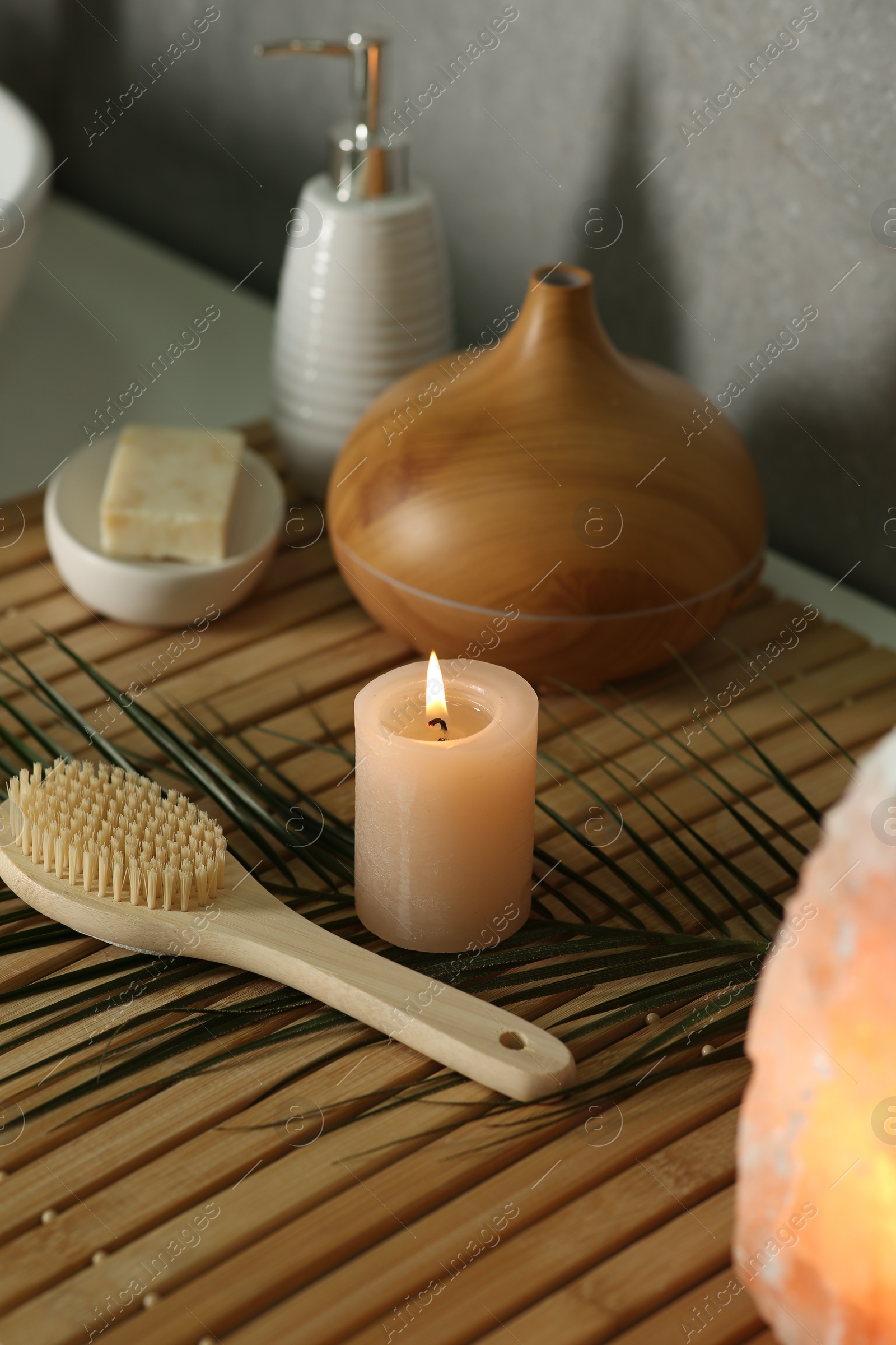 Photo of Composition with different spa products and burning candle on table