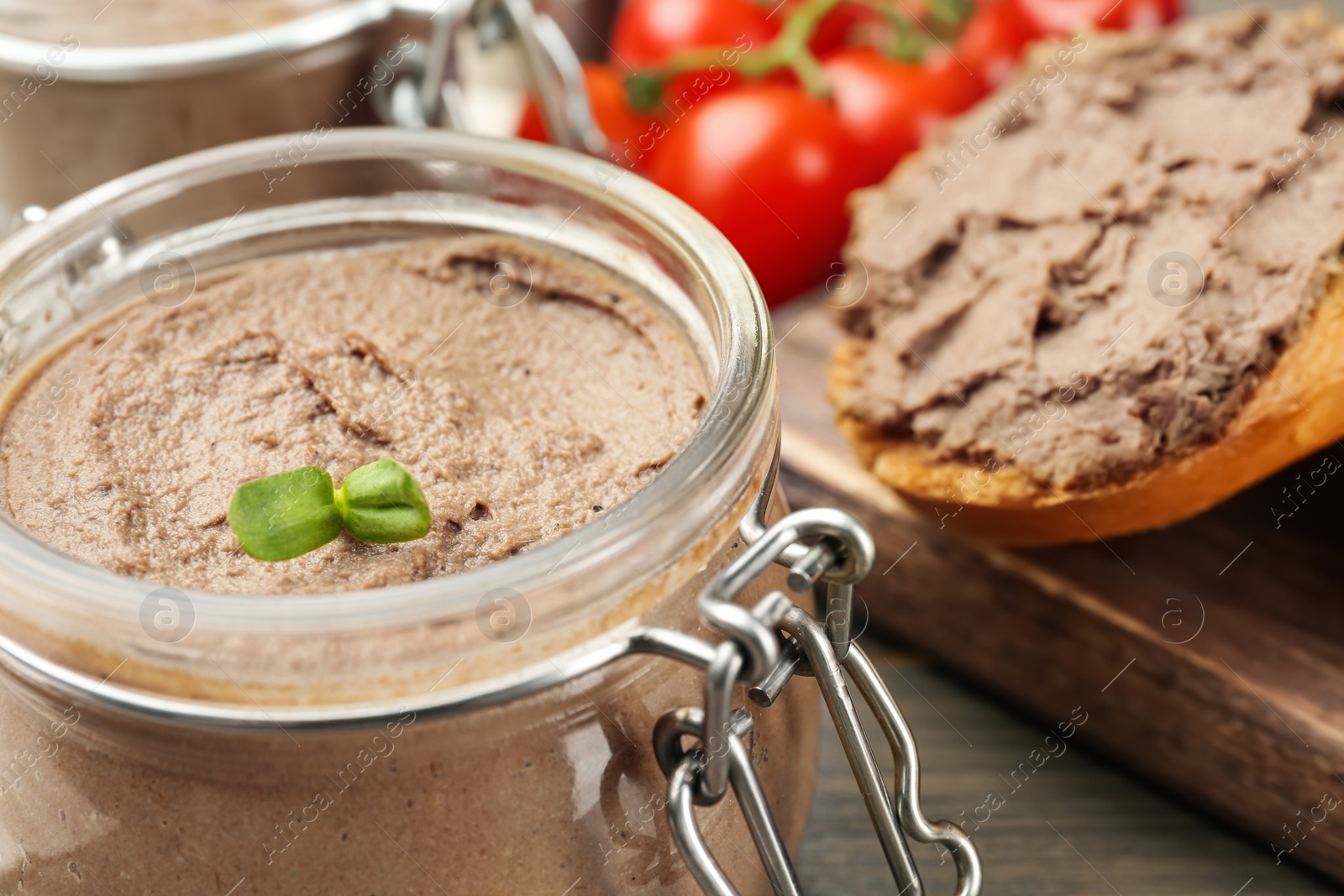 Photo of Glass jar with delicious liver pate on table, closeup. Space for text