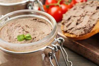 Photo of Glass jar with delicious liver pate on table, closeup. Space for text