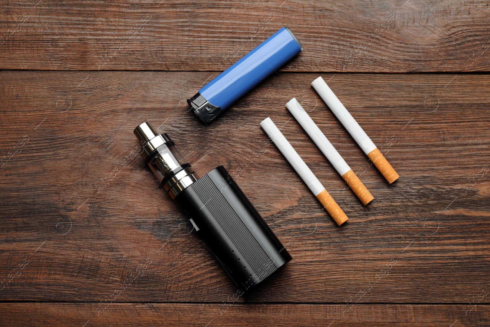 Photo of Cigarettes, lighter and vaping device on wooden background, flat lay. Smoking alternative