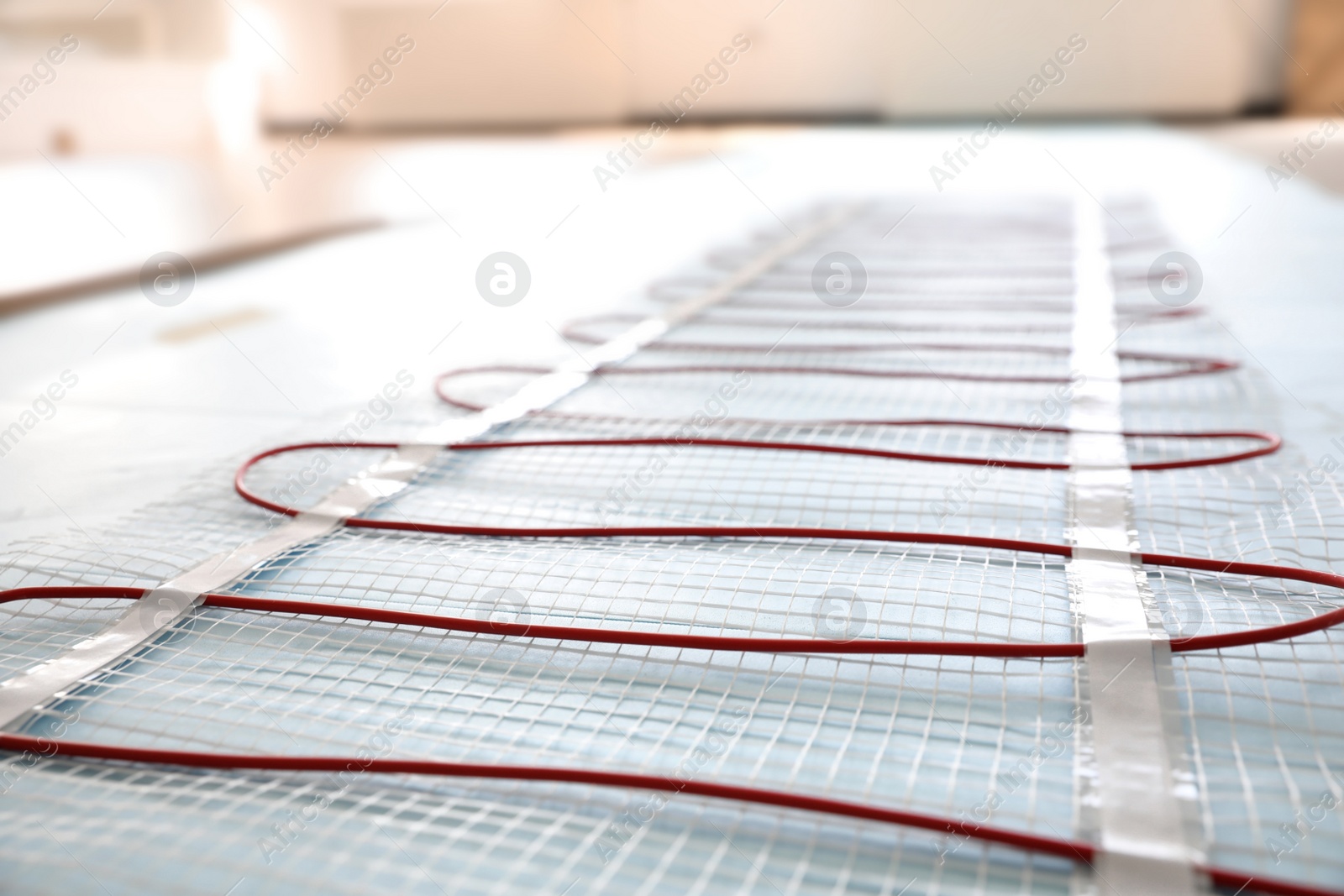 Photo of Installation of modern underfloor trace heating system indoors, closeup