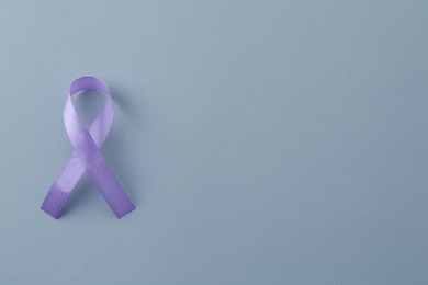 Photo of Violet awareness ribbon on light blue background, top view. Space for text
