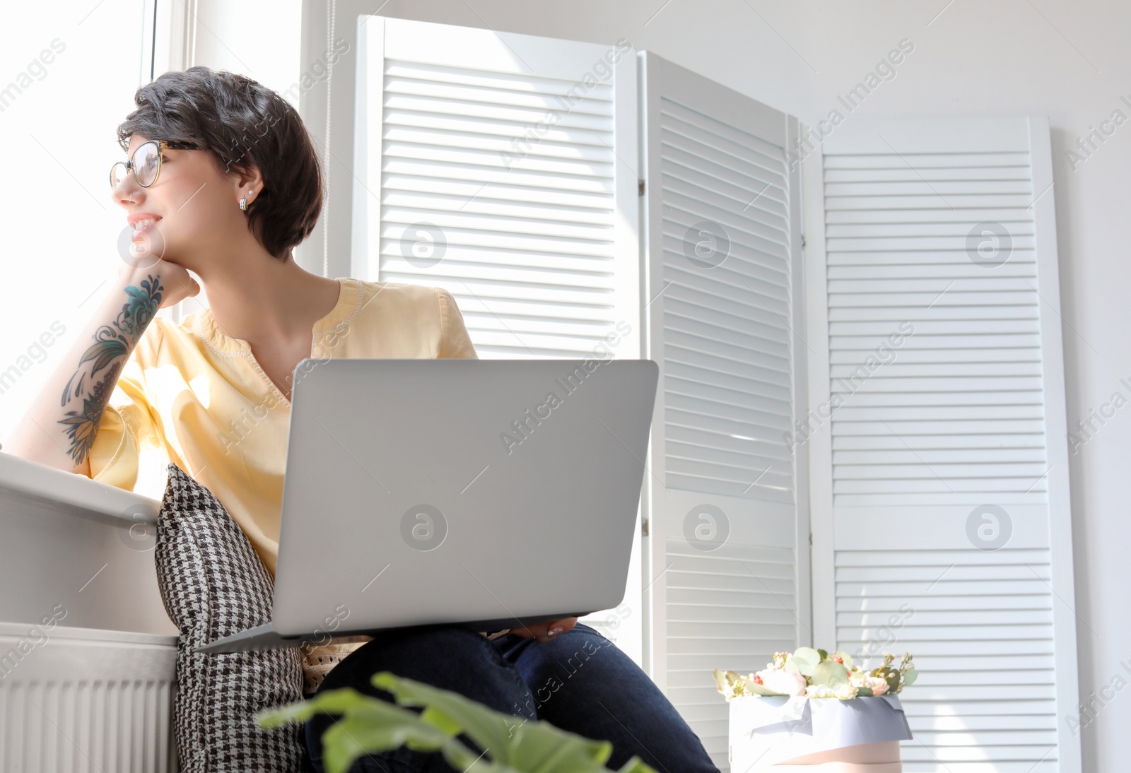 Photo of Young woman working with laptop at home