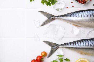 Raw mackerel, tomatoes and ice on white tiled table, flat lay. Space for text