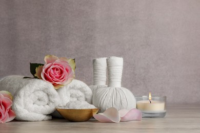 Photo of Composition with spa products, roses and candle on grey wooden table. Space for text