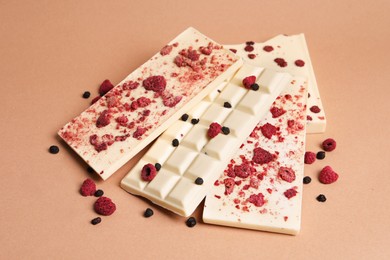 Photo of White chocolate bars with freeze dried fruits on beige background