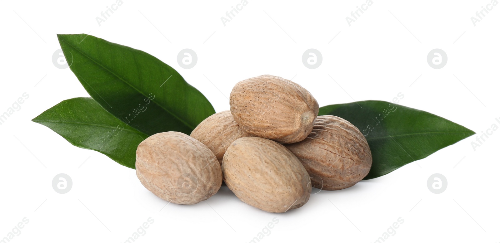 Photo of Nutmeg seeds with green leaves on white background