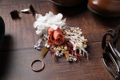 Wedding stuff. Composition with stylish boutonniere on wooden background, closeup